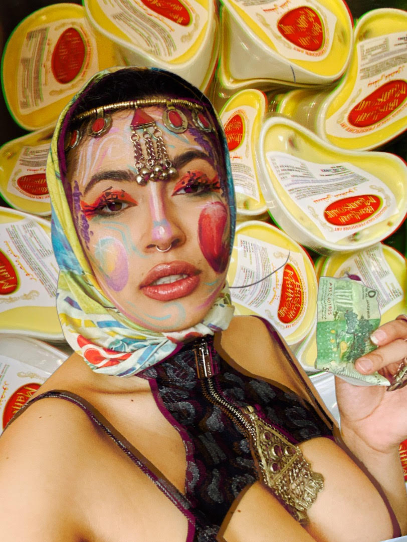 In the picture is a fictional person with big eyelashes, golden headdress, a colorful headscarf, a nose piercing and a revealing vest. The person is holding a banknote in their hand. A photomontage of Persian ice cream blurs in the background. 