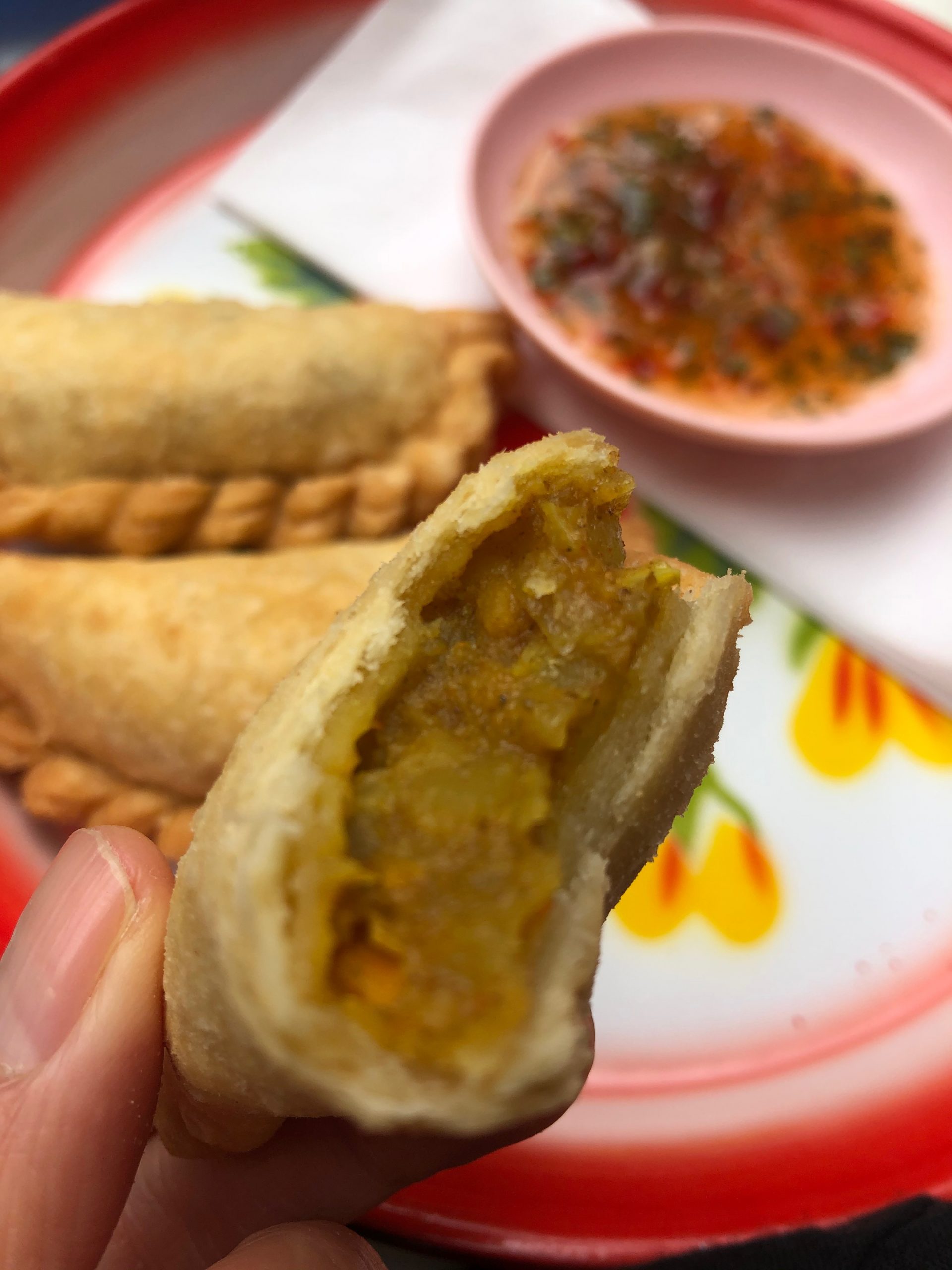 Curry Puffs mit Füllung und Soße. Curry Puffs sind ein malaiischer, singapurischer und thailändischer Snack.
